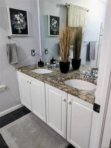 a bathroom with a granite countertop sink a mirror and vanity