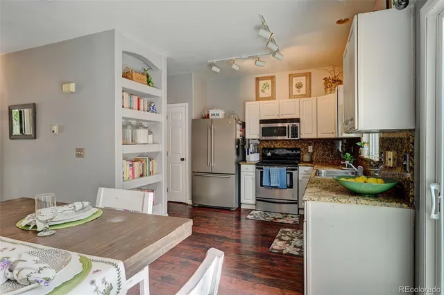 a kitchen with stainless steel appliances granite countertop a refrigerator and a stove top oven