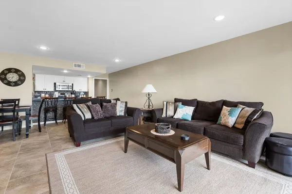 a living room with furniture and view of kitchen