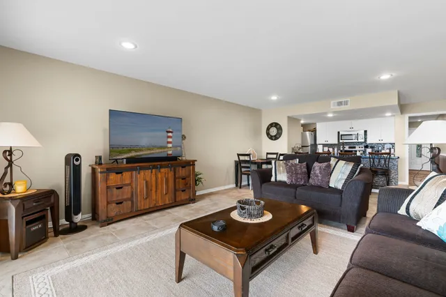 a living room with furniture a flat screen tv and a table