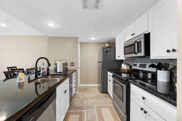 a kitchen with granite countertop a stove and a sink