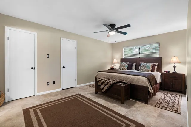 a bedroom with a large bed and a chandelier