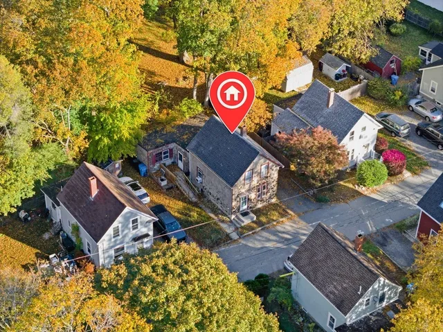 an aerial view of a red and white house with a street sign on the side of it
