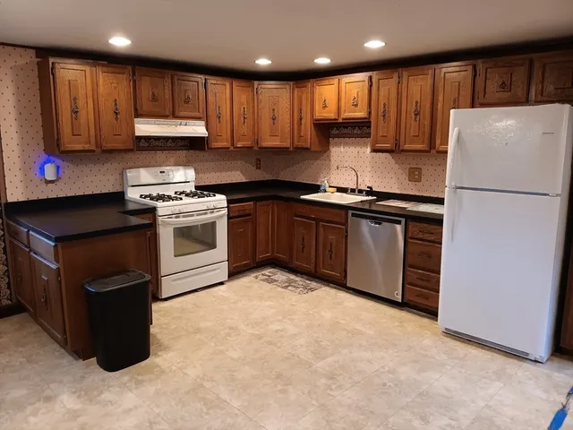 a kitchen with kitchen island granite countertop stainless steel appliances