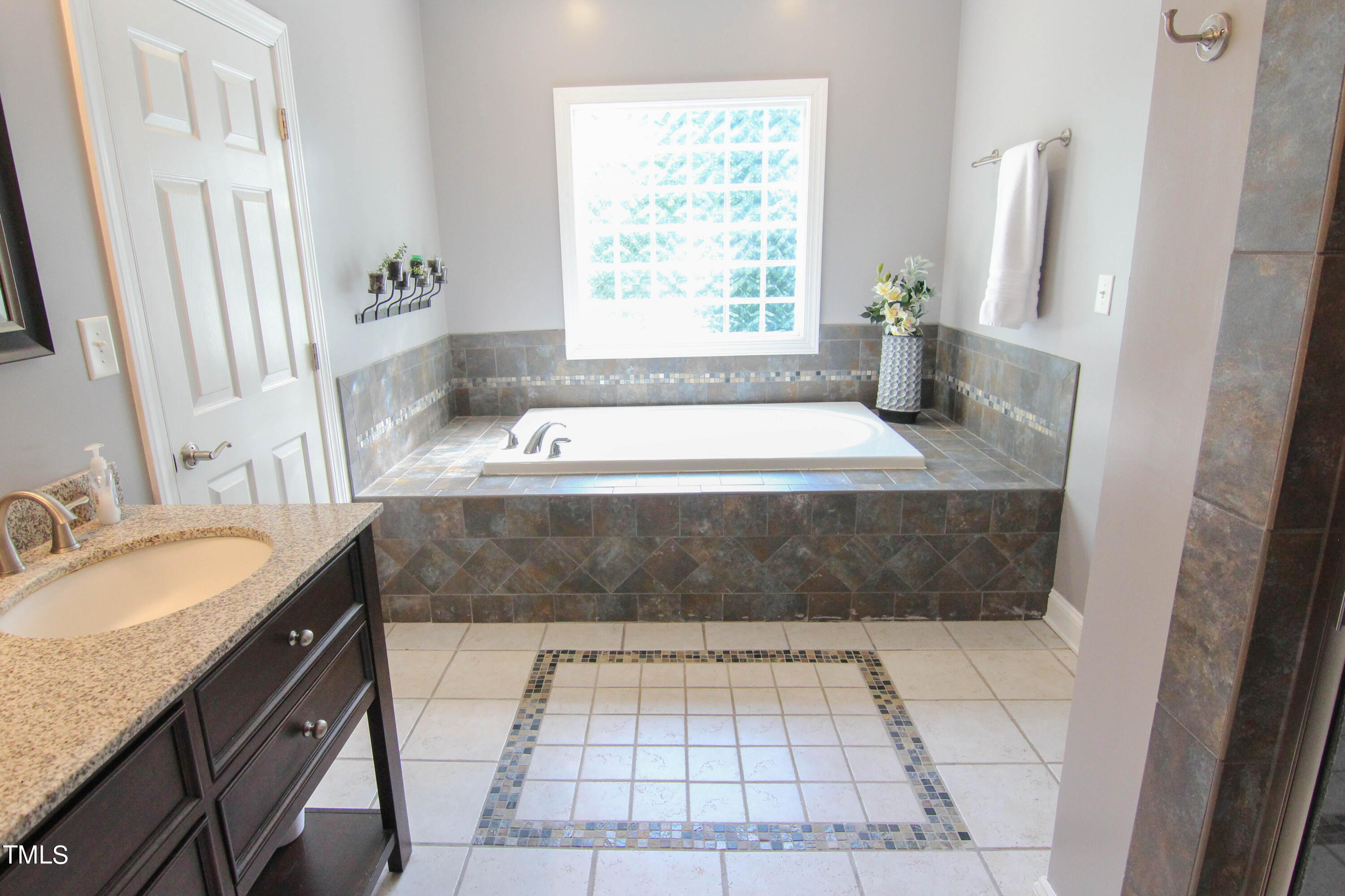 679 Roberts Chapel Road Stem, NC 27581 - Photo 12 of 28 a bathroom with a granite countertop bathtub sink and window