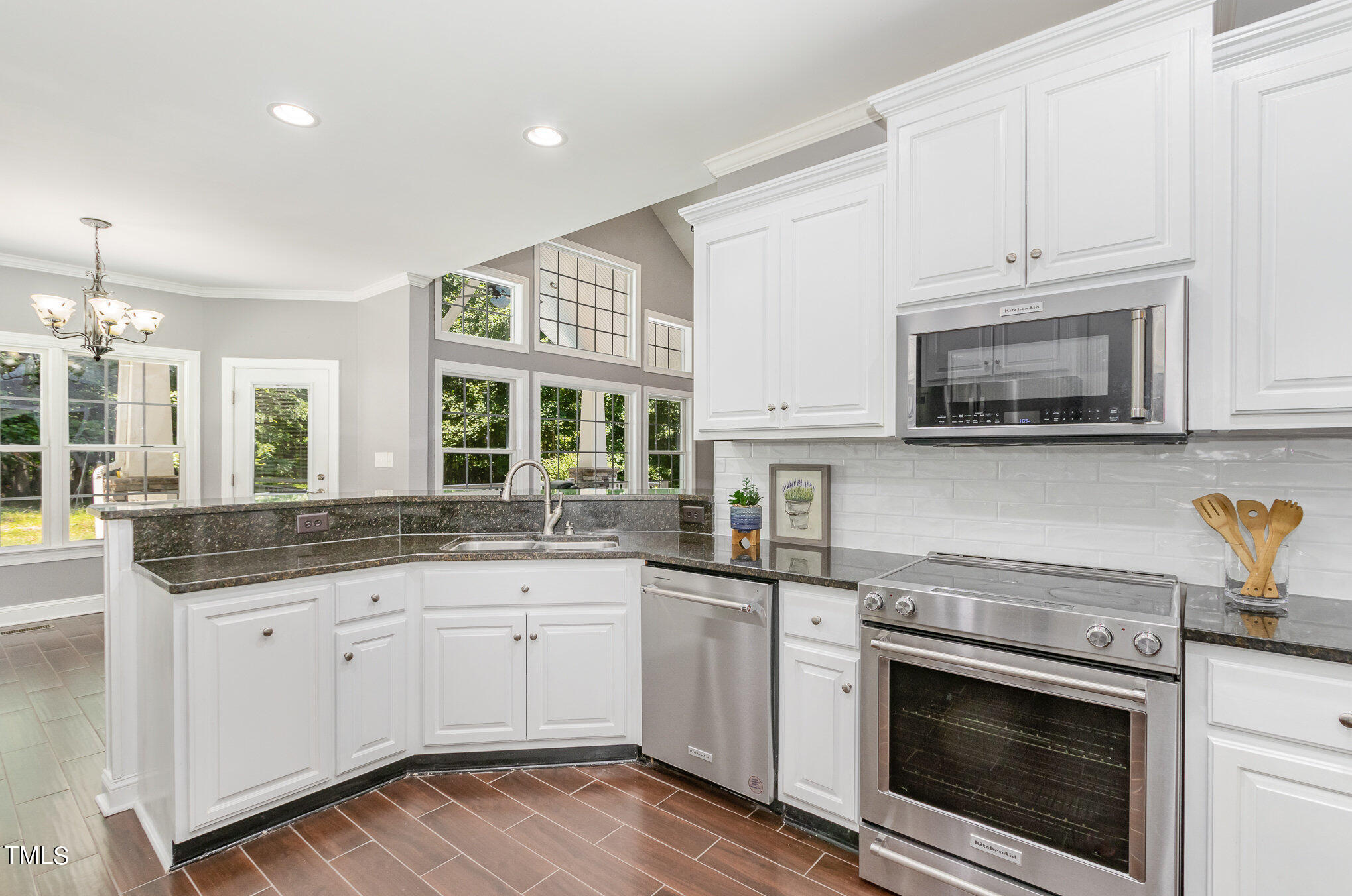 679 Roberts Chapel Road Stem, NC 27581 - Photo 6 of 28 a kitchen with granite countertop white cabinets stainless steel appliances a sink and a window