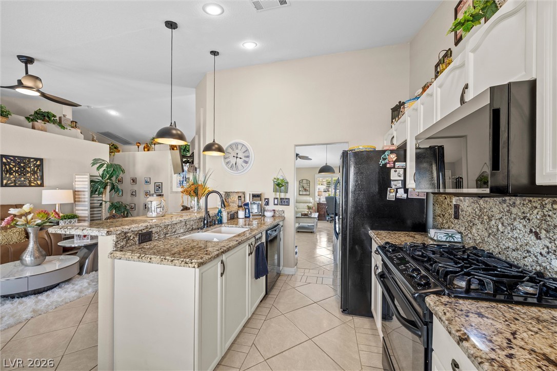 814 Manor Shores Road Henderson, NV 89002 - Photo 5 of 40 Gleaming stone countertops and classic cabinetry anchor this airy, open-concept kitchen space.