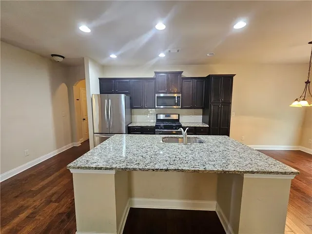 a kitchen with stainless steel appliances granite countertop a refrigerator microwave and stove