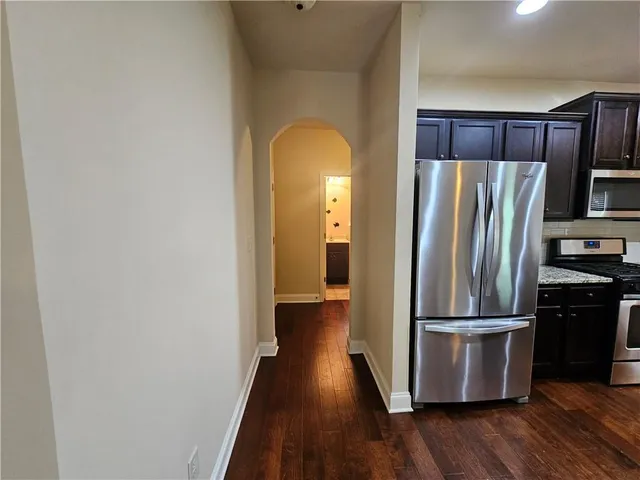 a kitchen with kitchen island granite countertop stainless steel appliances and wooden cabinets