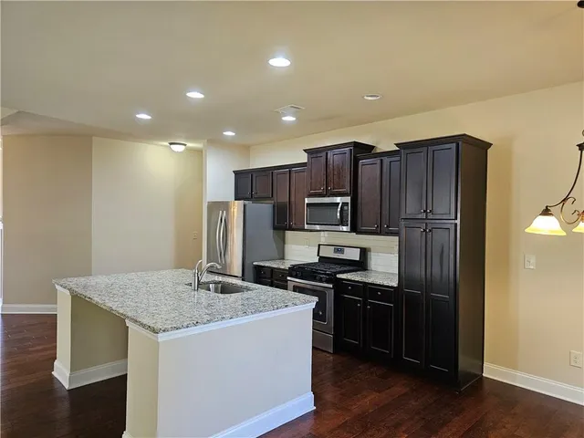 a kitchen with stainless steel appliances granite countertop a stove and a refrigerator