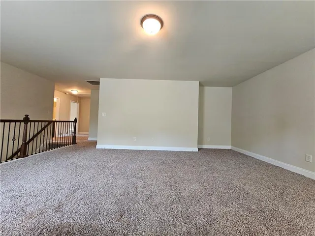a view of an empty room and chandelier fan