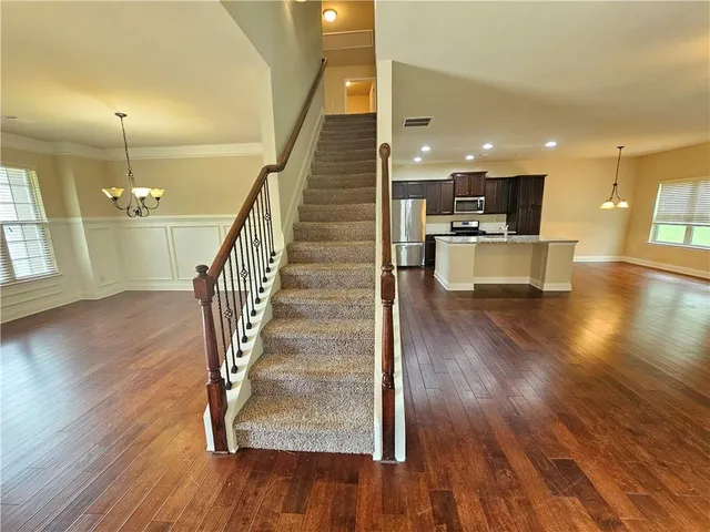 a view of entryway and kitchen with wooden floor