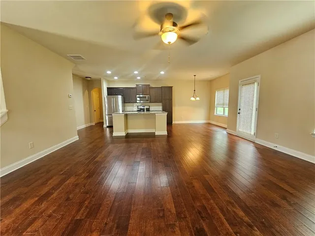 a view of a big room with wooden floor and windows