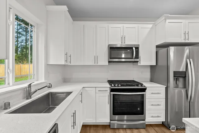 a kitchen with white cabinets and stainless steel appliances