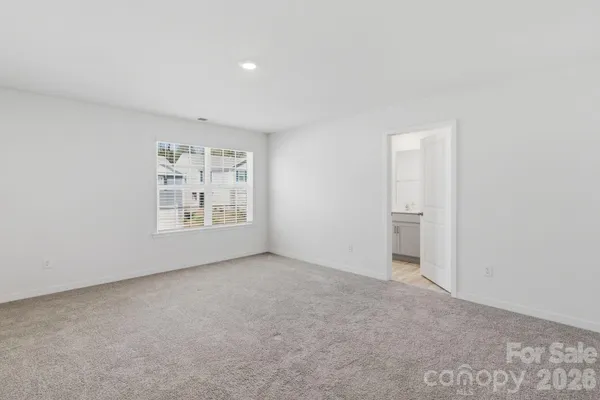 an empty room with windows and refrigerator