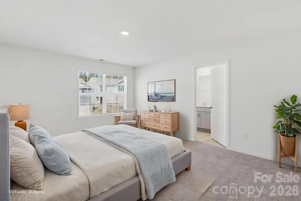 a bedroom with a bed and a potted plant