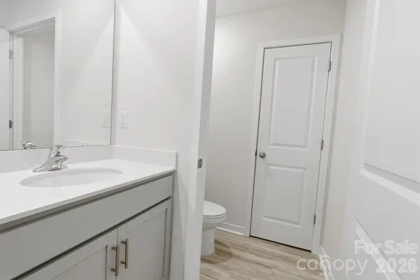 a bathroom with a granite countertop sink and a toilet