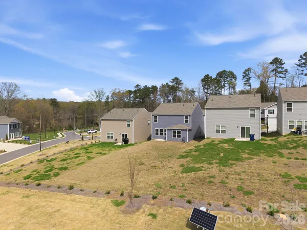 a view of a house with a big yard and large trees