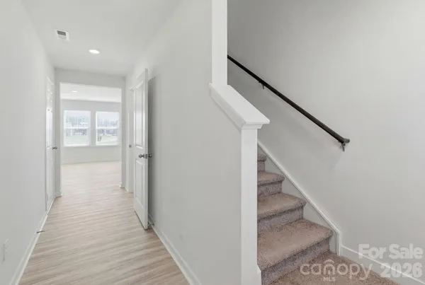 a view of a hallway with wooden floor and entryway