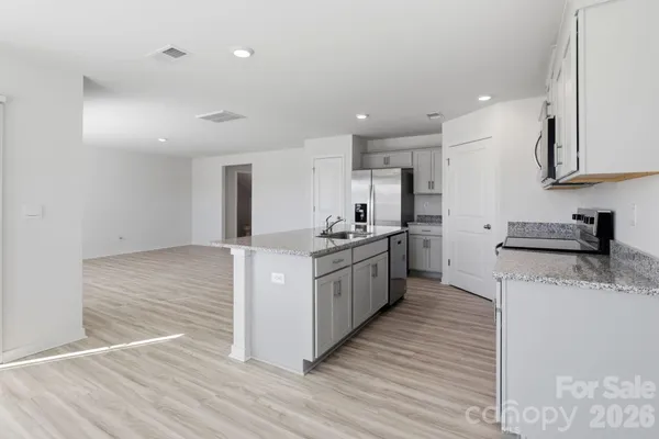 a kitchen with granite countertop a stove top oven sink and cabinets
