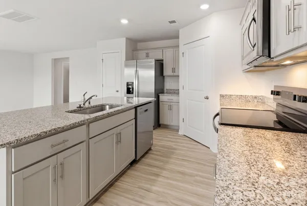 a kitchen with stainless steel appliances granite countertop a sink stove and refrigerator