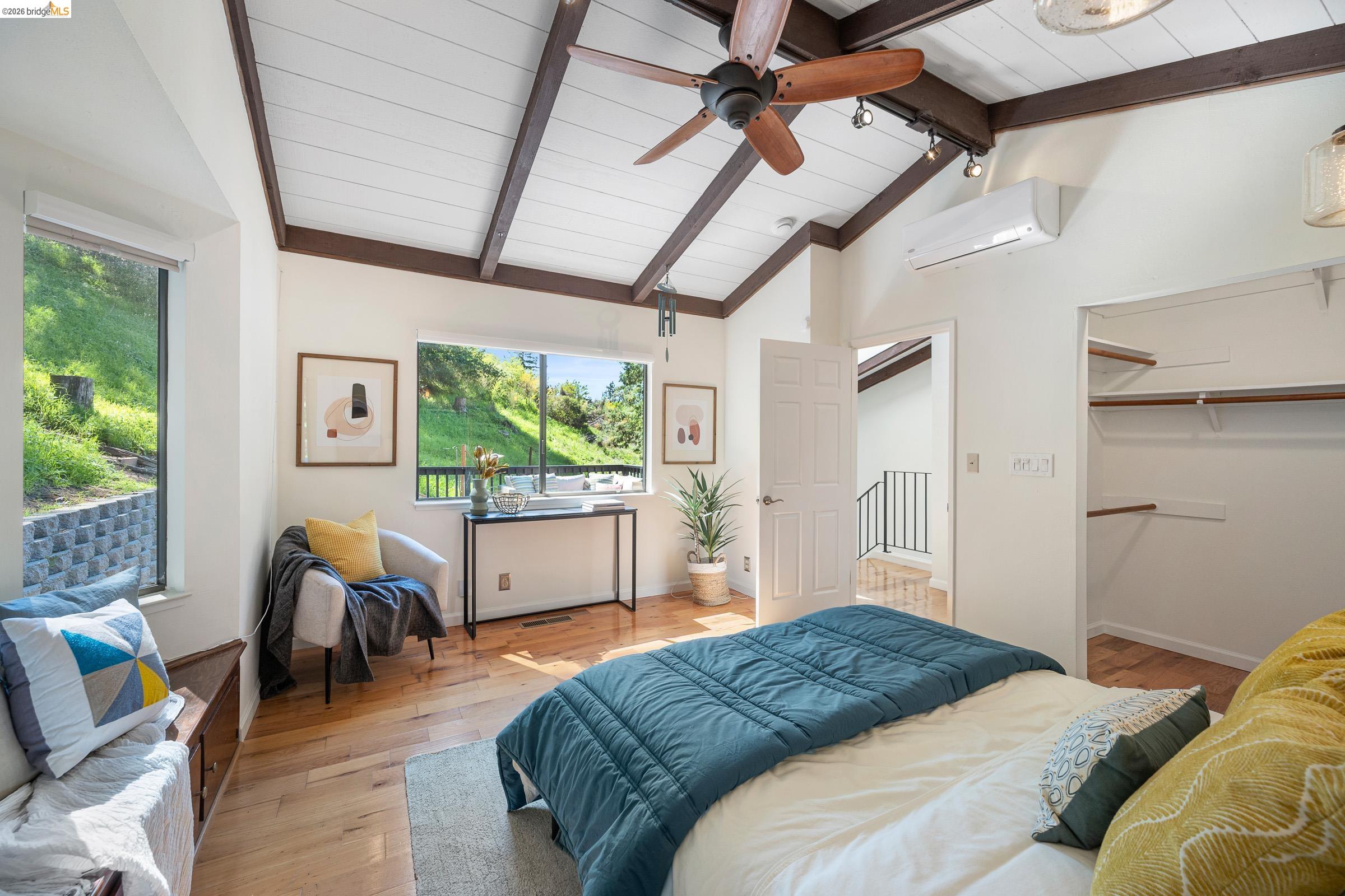 6600 Heather Ridge Way Oakland, CA 94611 - Photo 43 of 66 Vaulted ceiling with exposed wood beams, wood-finish flooring, built-in window seat, walk-in closet with shelving, and large windows