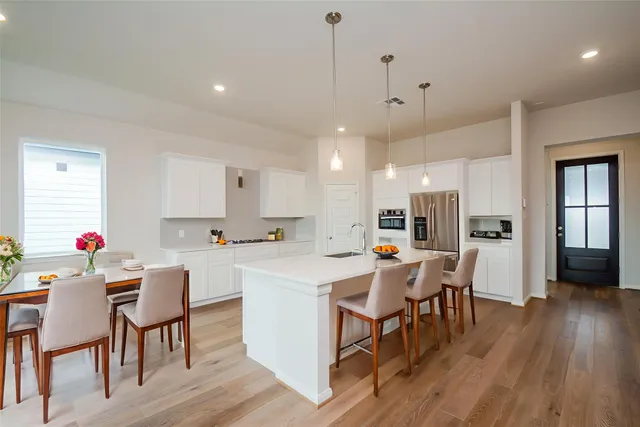 a kitchen with a sink a stove and chairs