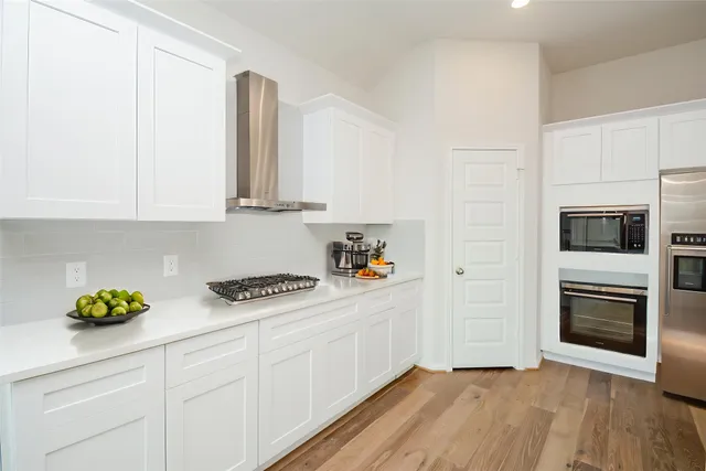 a kitchen with stainless steel appliances granite countertop a sink a refrigerator and a stove