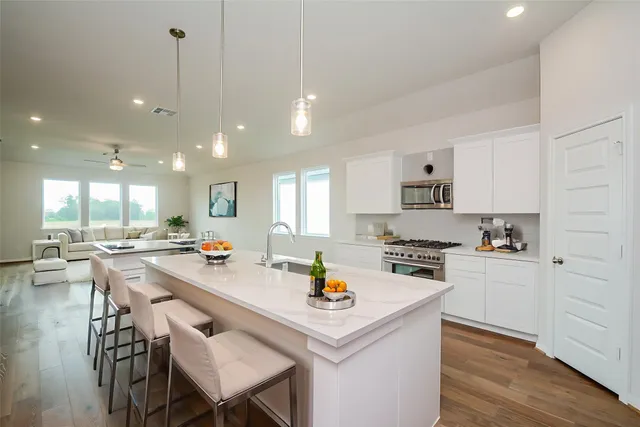 a kitchen with stainless steel appliances white cabinets and a stove a oven with wooden floor