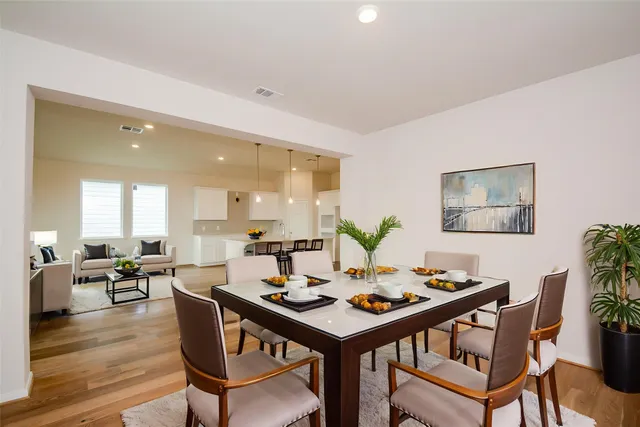 a kitchen with a stove a refrigerator and white cabinets with wooden floor