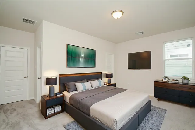 a bedroom with a bed and a flat tv screen on the dresser