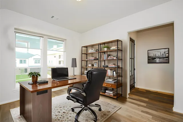 a view of a workspace with furniture and a window