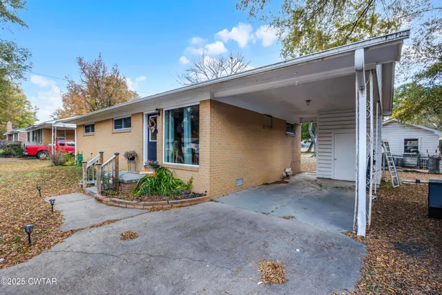 a view of a house with backyard and a patio