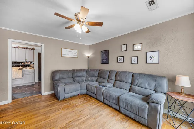 a living room with furniture and a wooden floor