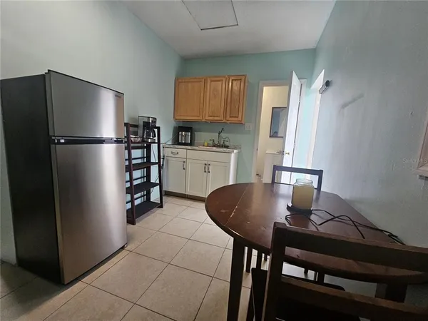 a kitchen with refrigerator and chairs