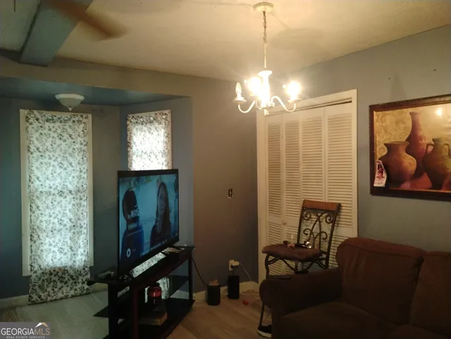 a view of a livingroom with furniture and chandelier fan