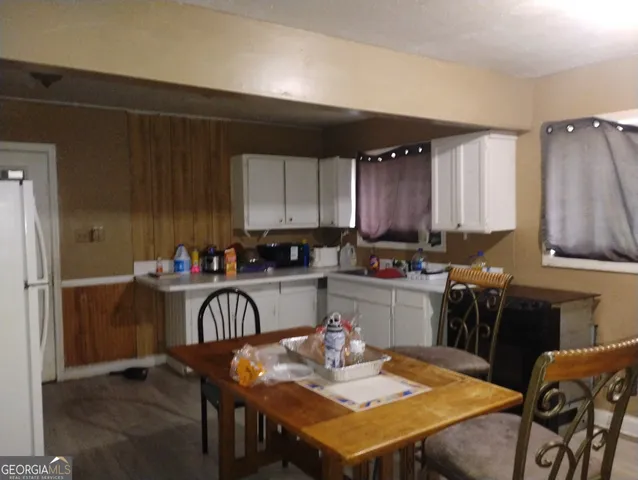 a kitchen with a table chairs and a refrigerator