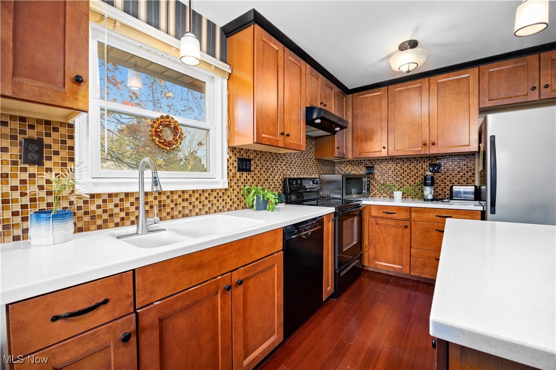 9265 Root Road North Ridgeville, OH 44039 - Photo 5 of 40 Remodeled Kitchen featuring solid surface countertops, Bosch dishwasher, electric stove, hanging light fixtures, and tasteful backsplash