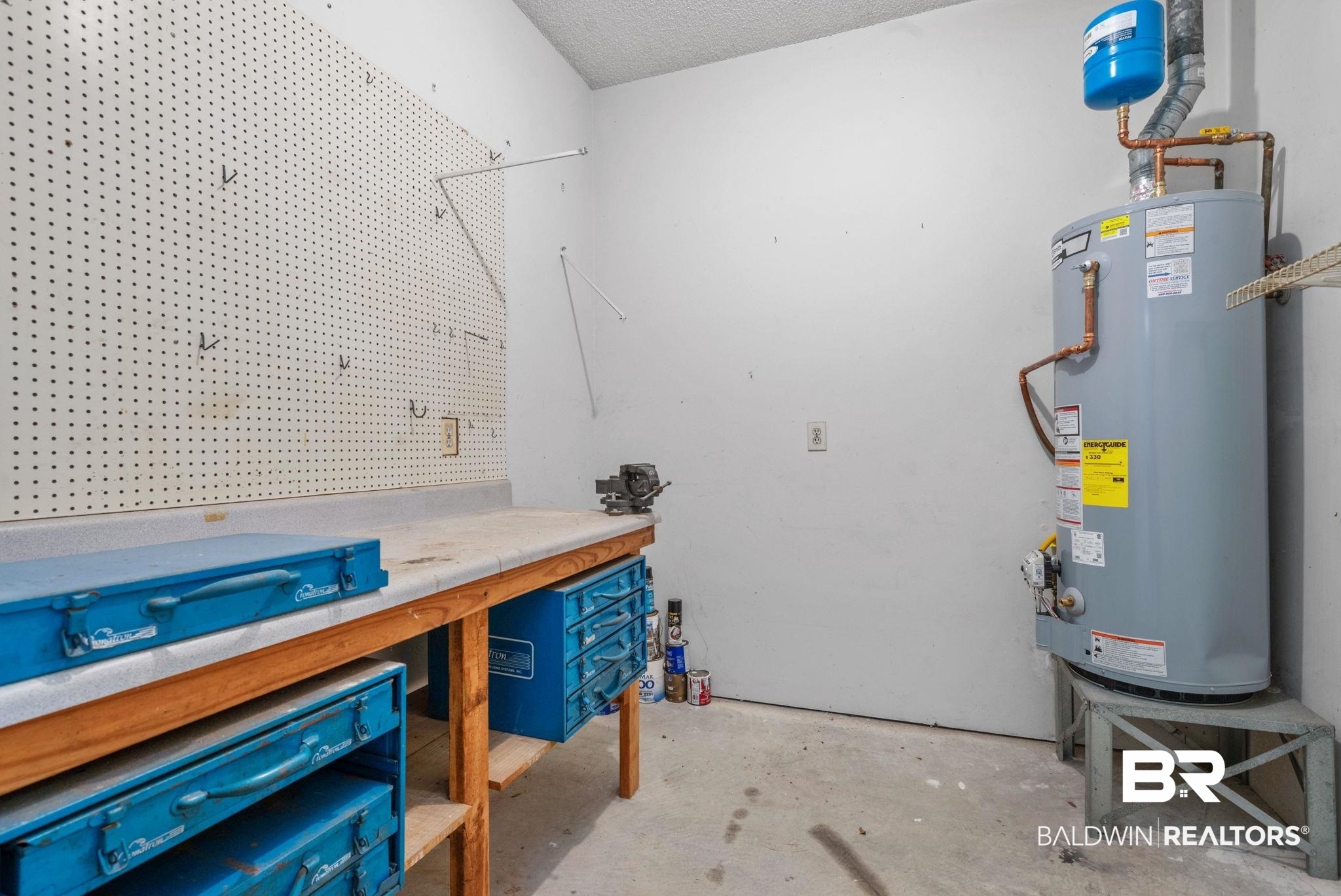 1340 Wellsley Court Mobile, AL 36695 - Photo 36 of 37 Misc room with unfinished concrete flooring, gas water heater, a textured ceiling, and a workshop area