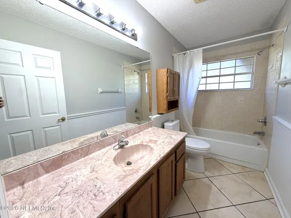 a bathroom with a granite countertop sink a toilet and bathtub