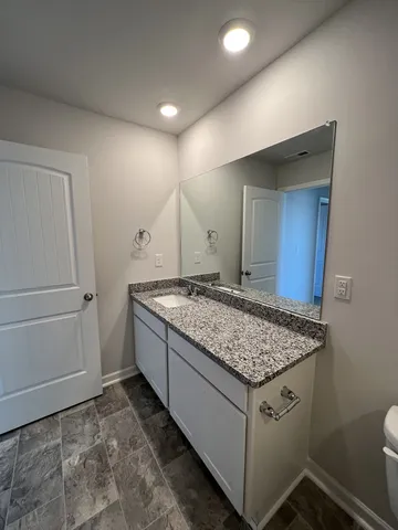 a bathroom with a granite countertop sink and a mirror