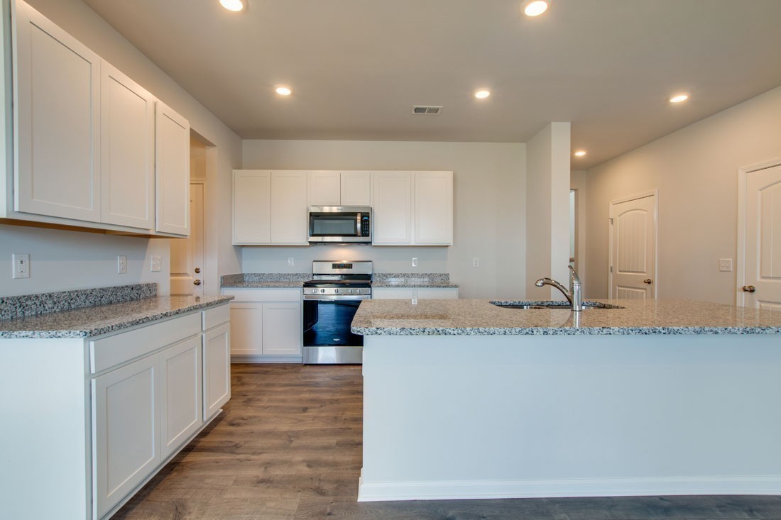 1703 Rylee Way Lebanon, TN 37087 - Photo 2 of 18 a kitchen with kitchen island granite countertop a sink a stove top oven and white cabinets