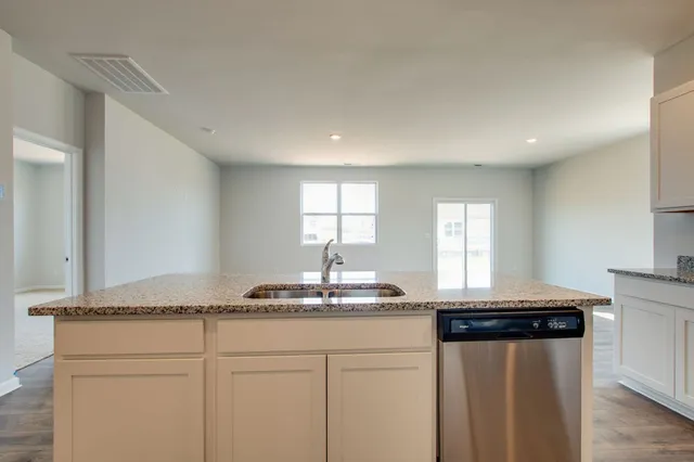 a kitchen with granite countertop cabinets stainless steel appliances and a window