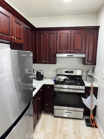 a kitchen with a stove a refrigerator and wooden cabinets