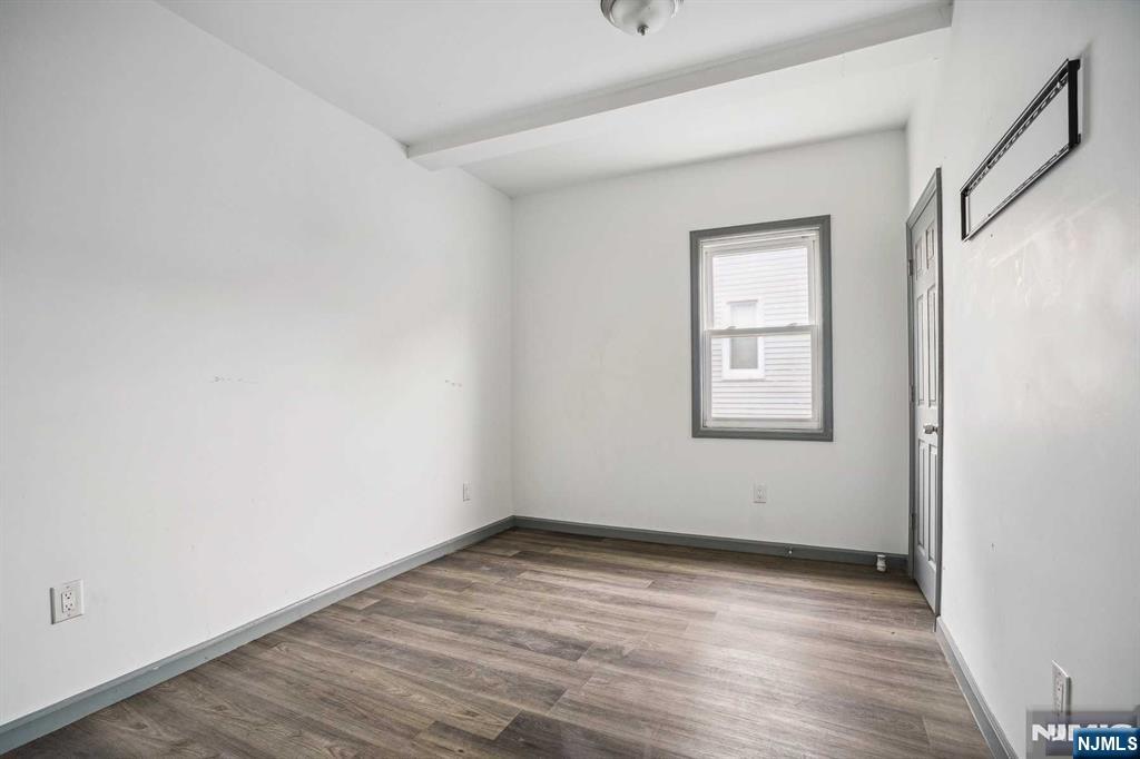 143 Valley Road, Unit 1R Montclair, NJ 07042 - Photo 11 of 18 an empty room with wooden floor and windows