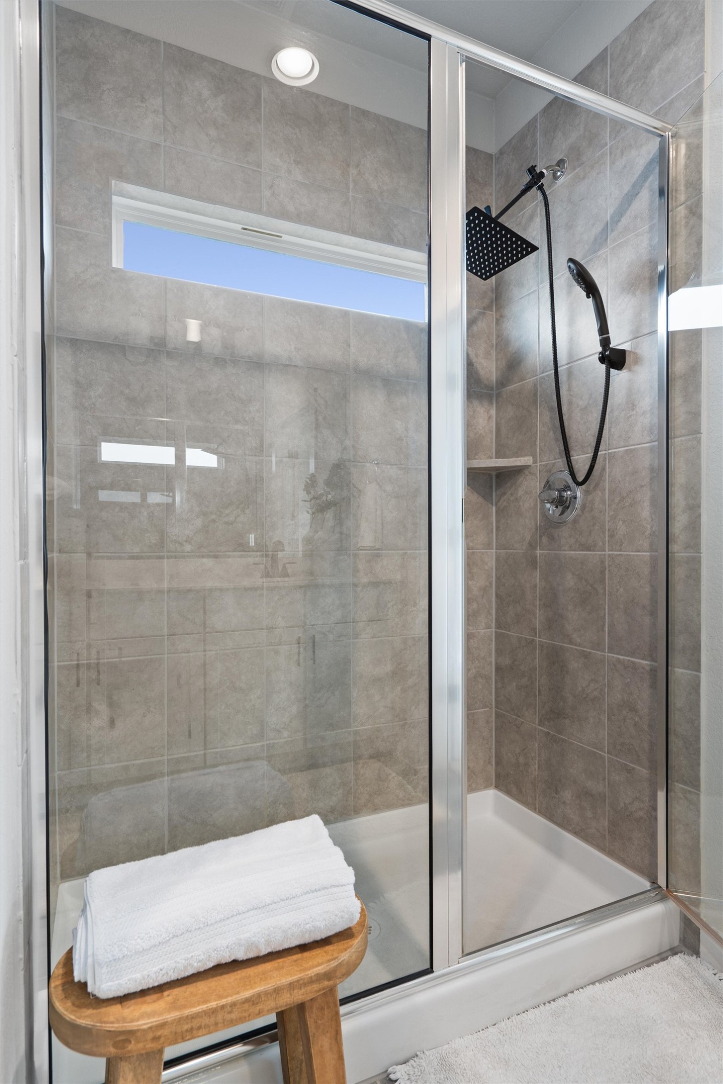 11620 Comano Drive Austin, TX 78747 - Photo 19 of 34 The shower features a glass enclosure, tiled walls, a rain shower head, and a handheld spray