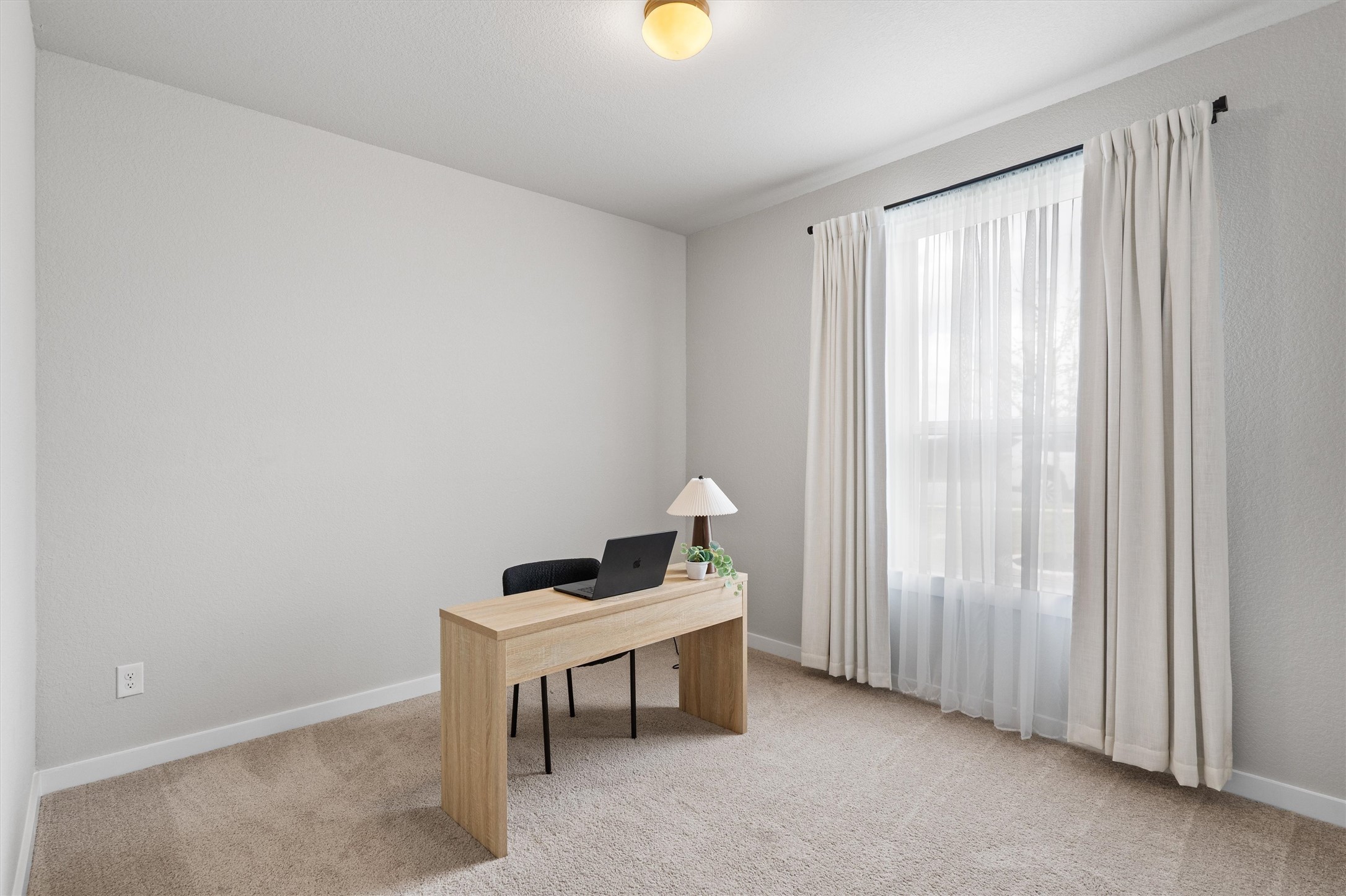 11620 Comano Drive Austin, TX 78747 - Photo 22 of 34 This versatile room features neutral-toned carpeting, light-colored walls, and a window with sheer and opaque curtains, providing flexibility for various uses