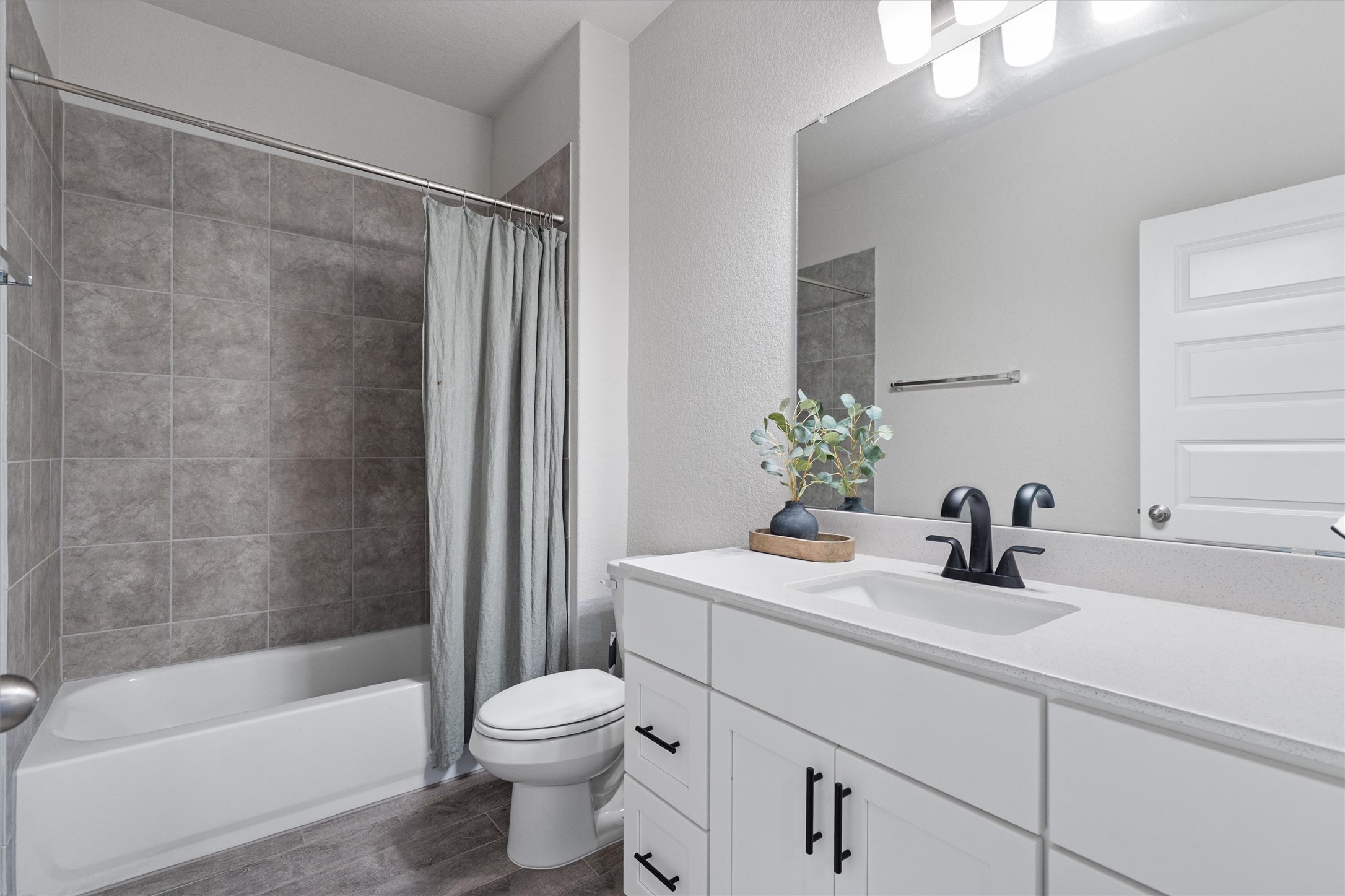 11620 Comano Drive Austin, TX 78747 - Photo 26 of 34 This bathroom features a spacious vanity with a white countertop and dark-colored fixtures