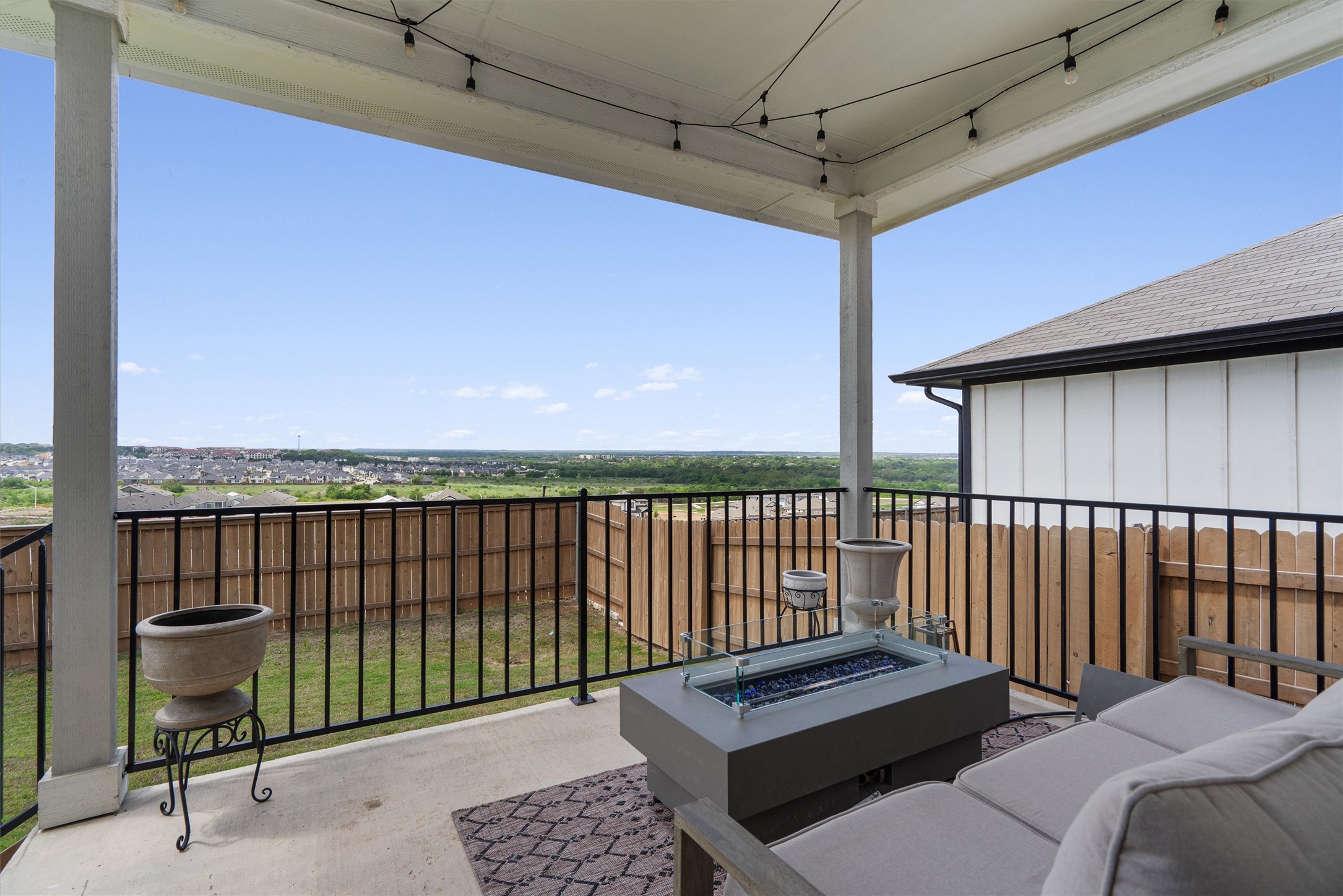 11620 Comano Drive Austin, TX 78747 - Photo 29 of 34 The property features a covered patio with string lights, providing an expansive view of the surrounding landscape
