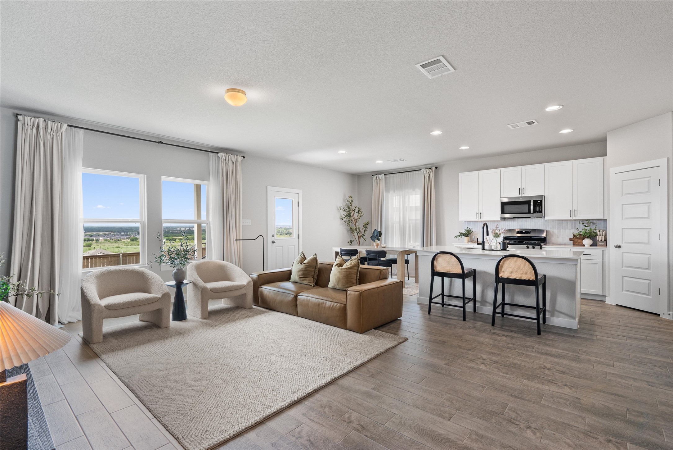11620 Comano Drive Austin, TX 78747 - Photo 6 of 34 Open-concept living space with large windows providing expansive views, recessed lighting, and wood-look flooring